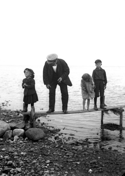 A man with three children on a jetty, Landskrona, Sweden, 1910. Artist: Unknown