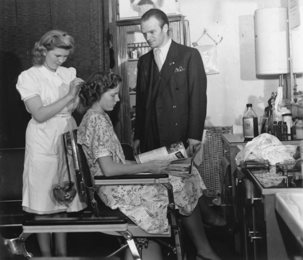 A girl passing the test to qualify as a hairdresser before a male inspector, Sweden, c1940-1959. Artist: Unknown