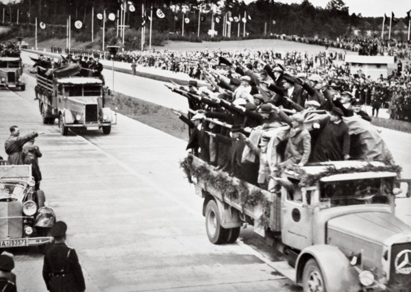Labourers salute Hitler from packed trucks on a Nazi-built road, 1936. Artist: Unknown