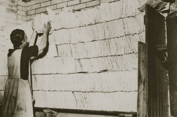 Stacking unleavened bread for the Passover in a Jewish bakery, 20th century. Artist: Unknown