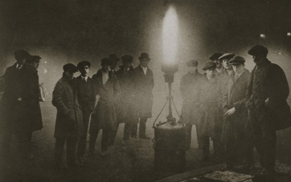Gathering around an acetylene flare at a traffic control point in the fog, early 20th century. Artist: Unknown