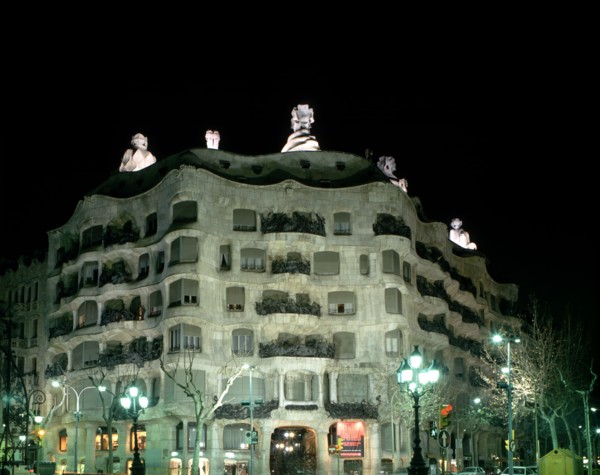 Façade of the Mila House or Pedrera lit at night, by Antoni Gaudí i Cornet (1852 - 1926).