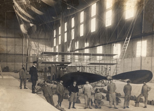 France. Hangar with the cockpit of an airship and a group of mechanics and pilots, 1900s.