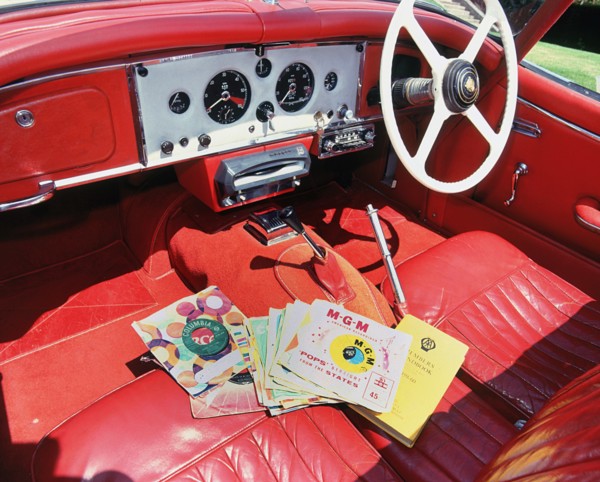 1960 Jaguar XK150 interior with record player and 7inch vinyl discs.. Creator: Unknown.