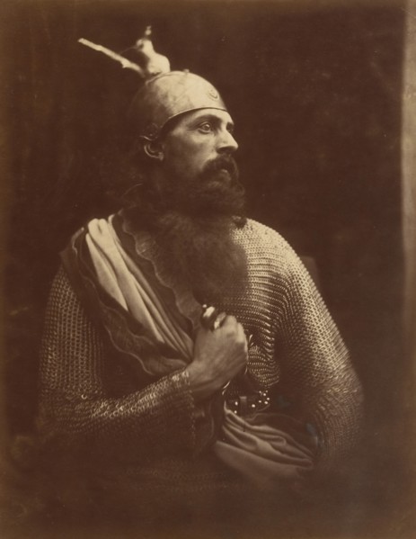 The Passing of King Arthur, 1874. A melodramatic depiction of Arthur?s death scene.  A bearded man (William Warder) in profile, wearing chainmail and an armour helmet with his right hand gripping a sw...