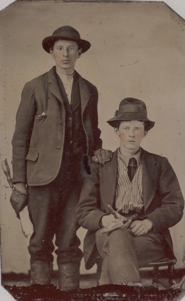 Two Young Men, One Seated and One Standing, Holding Carpentry Tools, 1870s-90s.