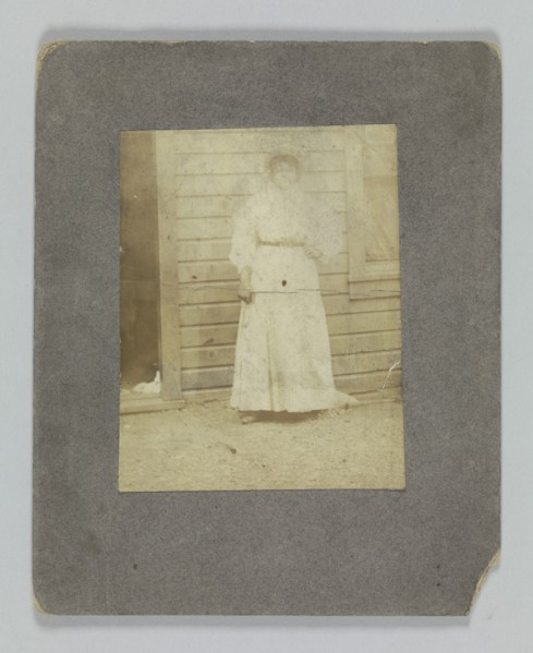 Photographic print of a woman in front of a building, late 19th century. Creator: Unknown.