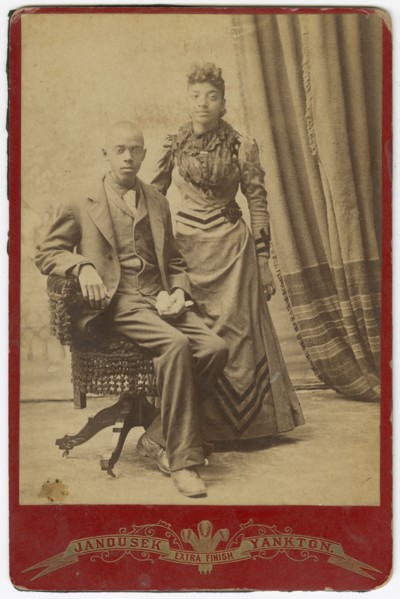 Photograph of African-American man and woman in formal clothes, late 19th century. Creator: Louis Janousek.