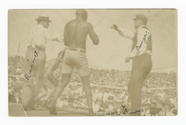 Photographic postcard of James J. Jeffries staggering away from Jack Johnson, 1910. Creator: Unknown.
