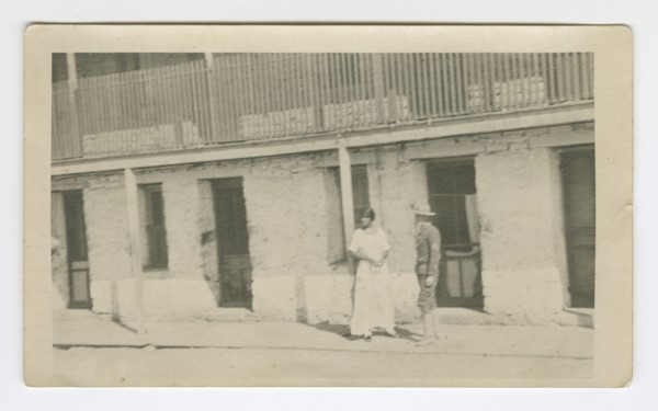Photograph of a man and woman standing on a sidewalk, early 20th century. Creator: Unknown.