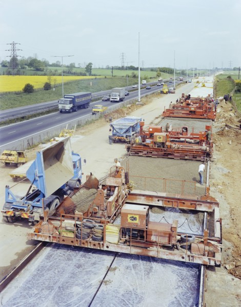 Slipform paving machines laying a road surface during widening works on the M1, 18/05/1982. Creator: John Laing plc.