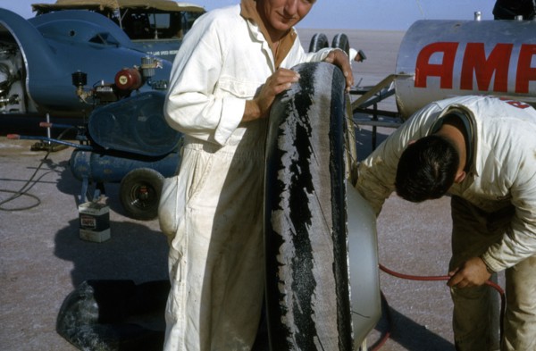 Mechanics inflating Bluebird CN7 tyre for World Land Speed Record attempt, Lake Eyre, 1964. Creator: Unknown.