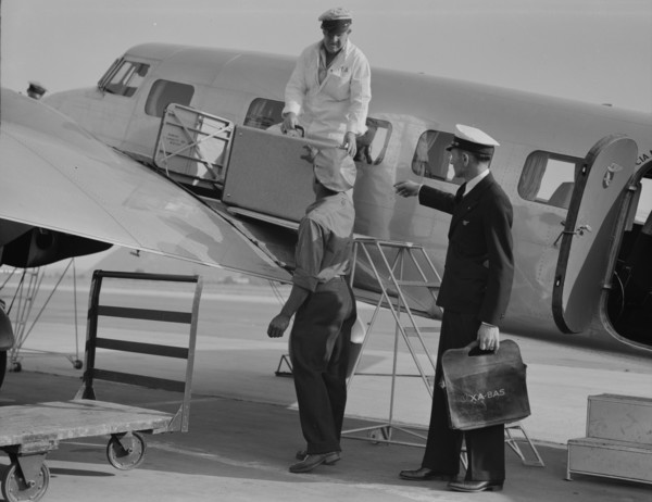 Unloading baggage for inspection...plane from Mexico, Glendale Airport, California, 1937. Creator: Dorothea Lange.