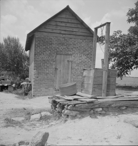 Well and old plantation smokehouse, Chesnee, South Carolina, 1937. Creator: Dorothea Lange.