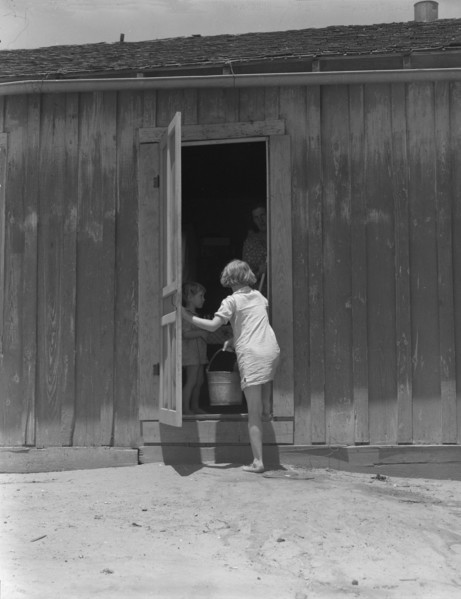 Child of Texas sharecropper carrying water, 1937. Creator: Dorothea Lange.