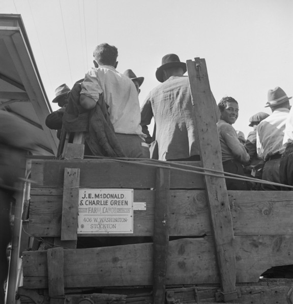 Labor contractor's truck with gang of pea pickers pulled up for gas, Westley, California, 1939. Creator: Dorothea Lange.