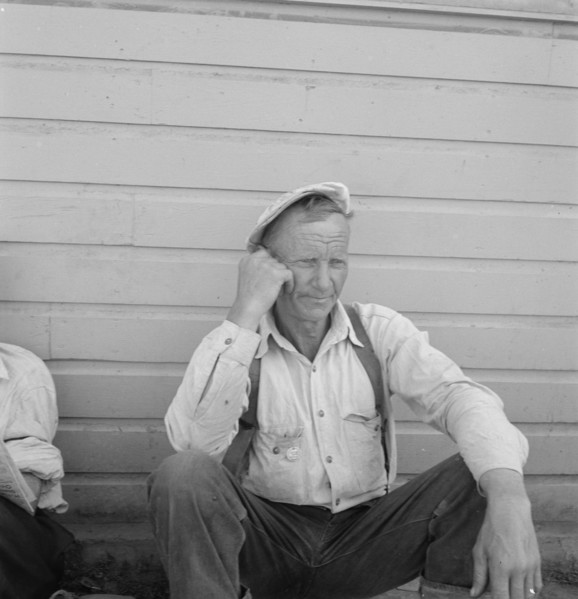 Bindle stiff, used to be logger, Side of Pastime Café, Tulelake, Siskiyou County, California, 1939. Creator: Dorothea Lange.