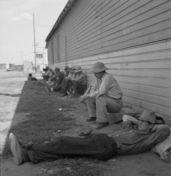 Idle men seated in shade on the other side of..., Tulelake, Siskiyou County, California, 1939. Creator: Dorothea Lange.