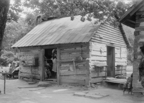 Double log cabin of Negro share tenants who raise tobacco, Person County, North Carolina, 1939. Creator: Dorothea Lange.