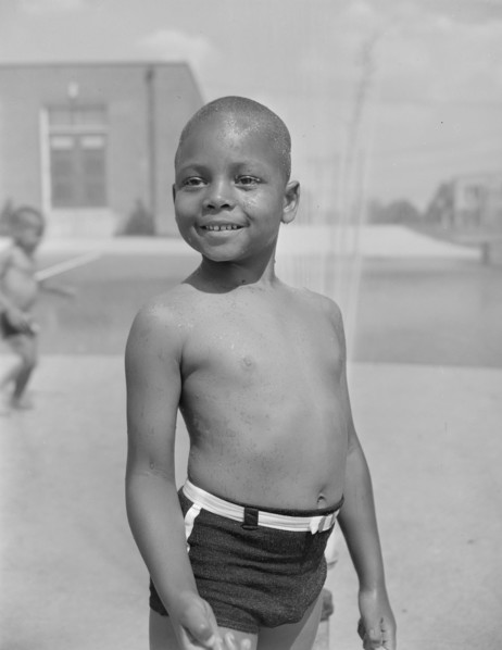 Anacostia, D.C. Frederick Douglass housing project. Cooling off under the community sprayer.