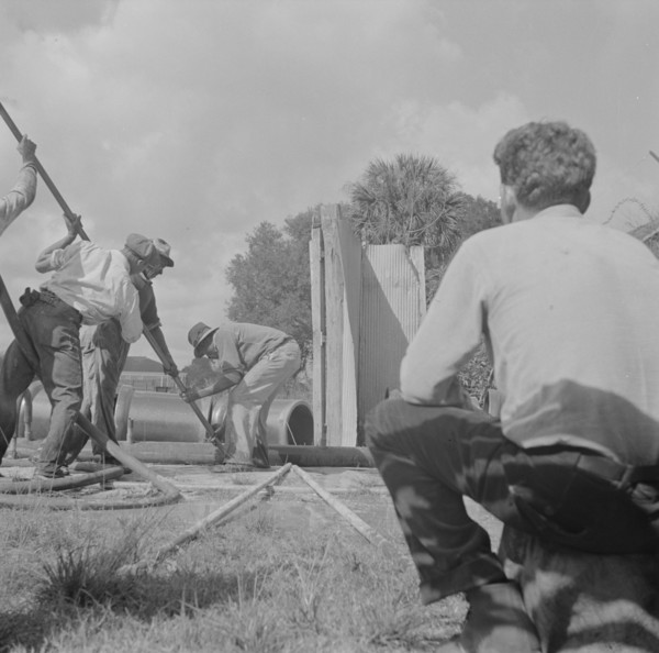 Daytona Beach, Florida. A foreman watching a Negro workman prepare to lay a sewer pipeline.