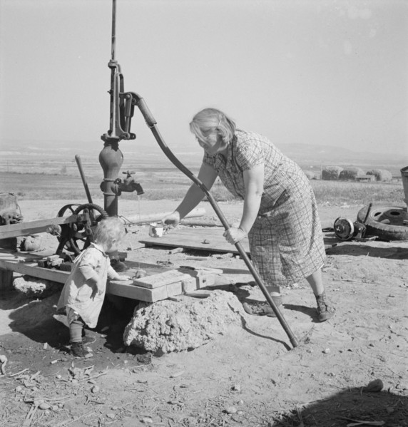 Mrs. Soper with youngest child at the well. Willow creek area, Malheur County, Oregon.