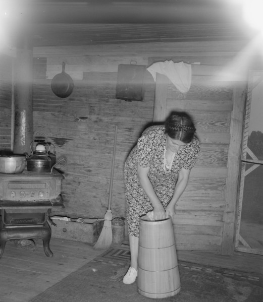 Wife of tobacco sharecropper cleaning butter churn. Person County, North Carolina.