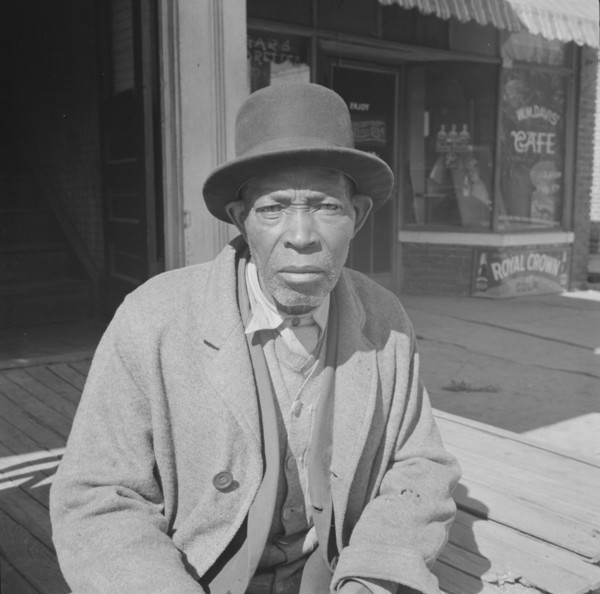 Daytona Beach, Florida. Men sitting in the sun on Sunday morning.