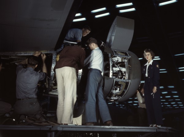 Installing an engine at the Consolidated Aircraft Corporation plant, Fort Worth, Texas, 1942. Creator: Howard Hollem.