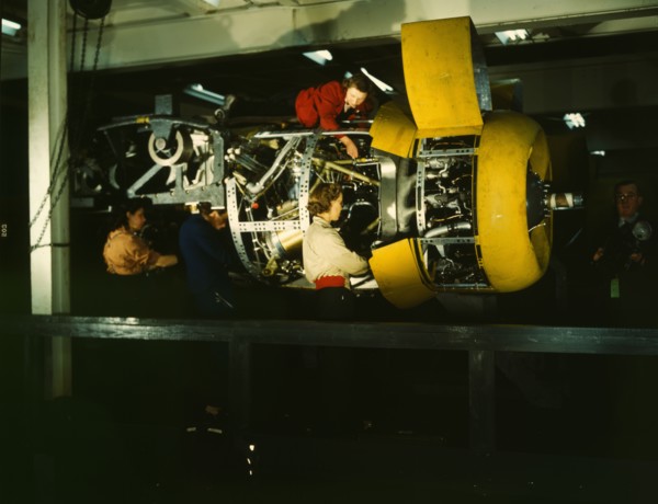 Installing one of the 4 motors on the transport plane at Willow Run, between 1941 and 1945. Creator: Howard Hollem.