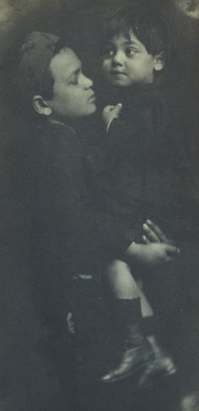 Young boy holding a smaller child, c1900.
