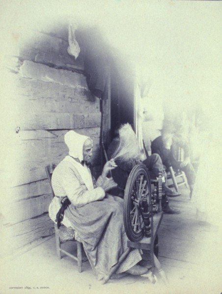 Elderly woman sitting on porch spinning, c1894.