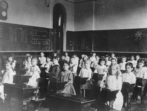 Girls and boys seated at desks in classroom, Washington, D.C., (1899?).