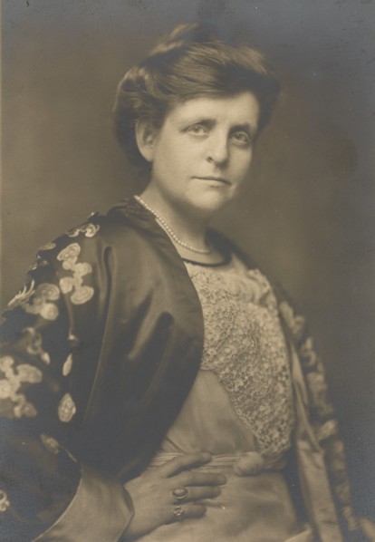 Frances Benjamin Johnston, half-length portrait, turned to the right, facing front, with right hand on hip, 1911.