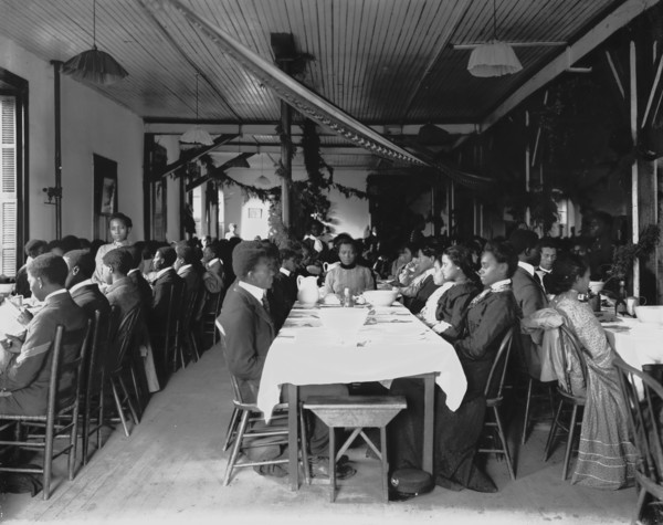 Interior view of dining hall, decorated for the holidays, with students... Tuskegee Institute, c1902 Creator: Frances Benjamin Johnston.
