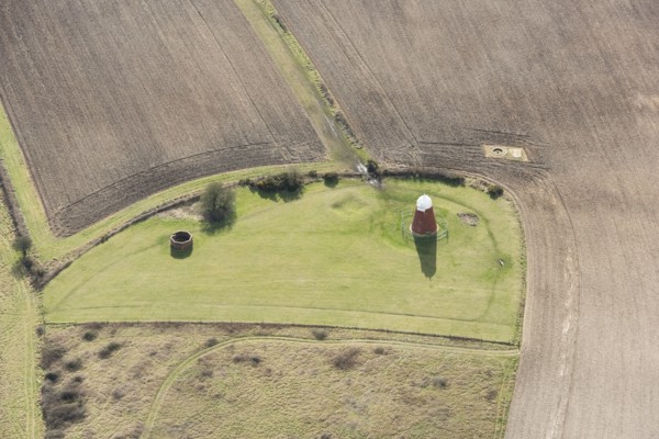 A tower windmill and World War II searchlight emplacements on Halnaker Hill causewayed enclosure, West Sussex, 2018.