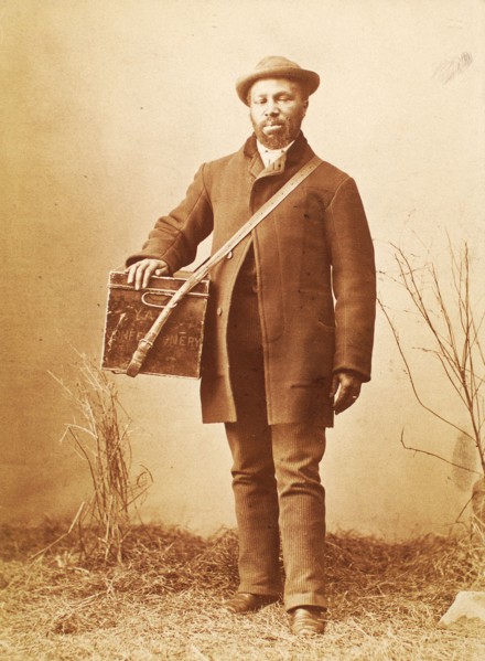Studio portrait of man holding box labelled 'Confectionery', c1880. Creator: William Notman.