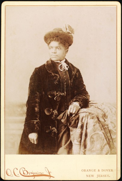Studio portrait of woman wearing hat, and velvet coat, c1880-c1889. Creators: O.C. Benjamin, Unknown.