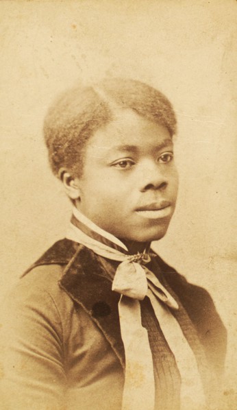 Portrait of young woman with velvet lapels and ribbon bow around neck, (1880-1889?). Creator: LV Bean.