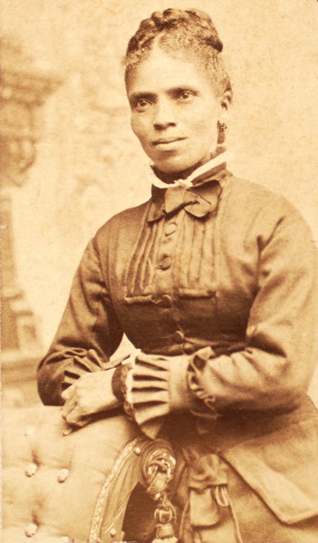 Studio portrait of unidentified woman, arms on back of chair, c1880-c1889. Creator: Richmond Photograph Co.