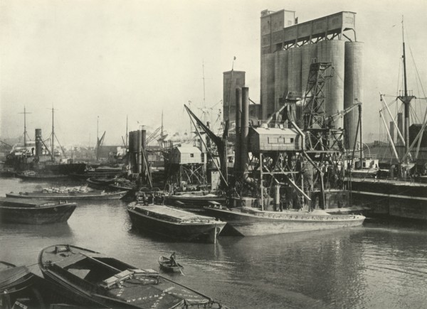 Factories, Refineries, Granaries Grow Thick Ship Discharging Grain by Floating Pneumatic...', 1937 Creator: J Dixon-Scott.