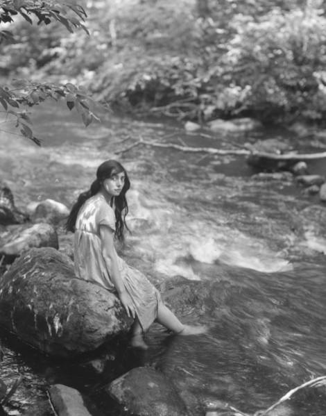 Cowan, Rosamonde, Miss (Rose Rolanda ; Mrs. Miguel C.), seated by a stream, 1919 May 24. Creator: Arnold Genthe.