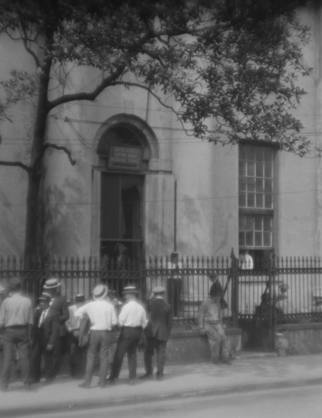 Men standing or sitting in front of the former Bank of Louisiana, 334 Royal Street..., c1920-1926. Creator: Arnold Genthe.