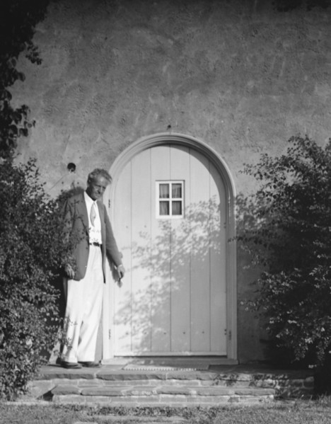Arnold Genthe standing outside by a door, between 1911 and 1942. Creator: Arnold Genthe.