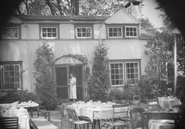 Mrs. Mary Benson standing at the entrance to her house, between 1933 and 1942. Creator: Arnold Genthe.