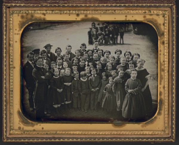 Large group of school children, with their teacher, standing in a town street, ca. 1850s. Creator: Unknown.