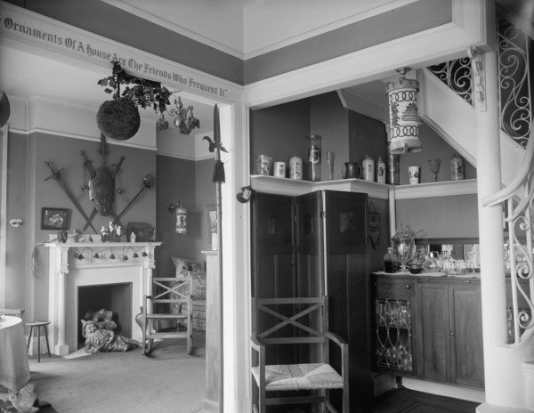 Hallway with liquor cabinet and living room decorated with mistletoe ball and Christm..., c1900-1915 Creator: Unknown.