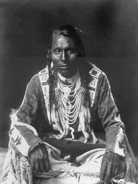 Wades in Water, Piegan Indian, full-length portrait, seated on floor, facing front..., c1910. Creator: Edward Sheriff Curtis.