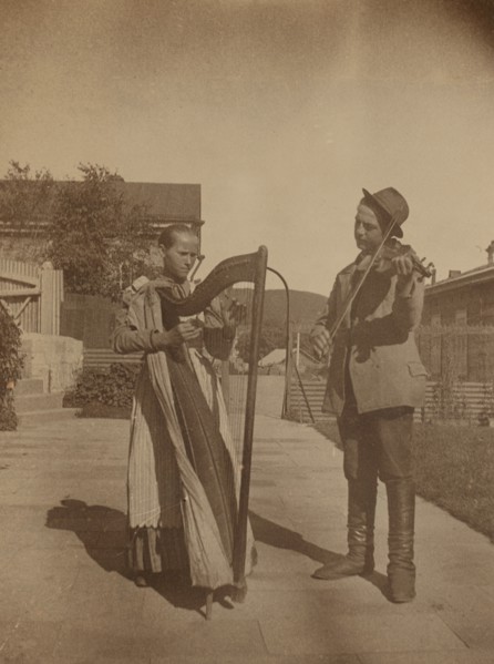 Street musicians with a harp and violin in the upper yard of Dom Smith, Vladivostok, Russia, (1899?) Creator: Eleanor Lord Pray.