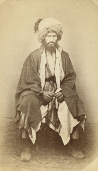 Full-length portrait of man, seated, facing front, between 1870 and 1886. Creator: Unknown.